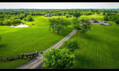 QUICK Aerial of this Multigenerational House Horse Property 25 acre Farm
