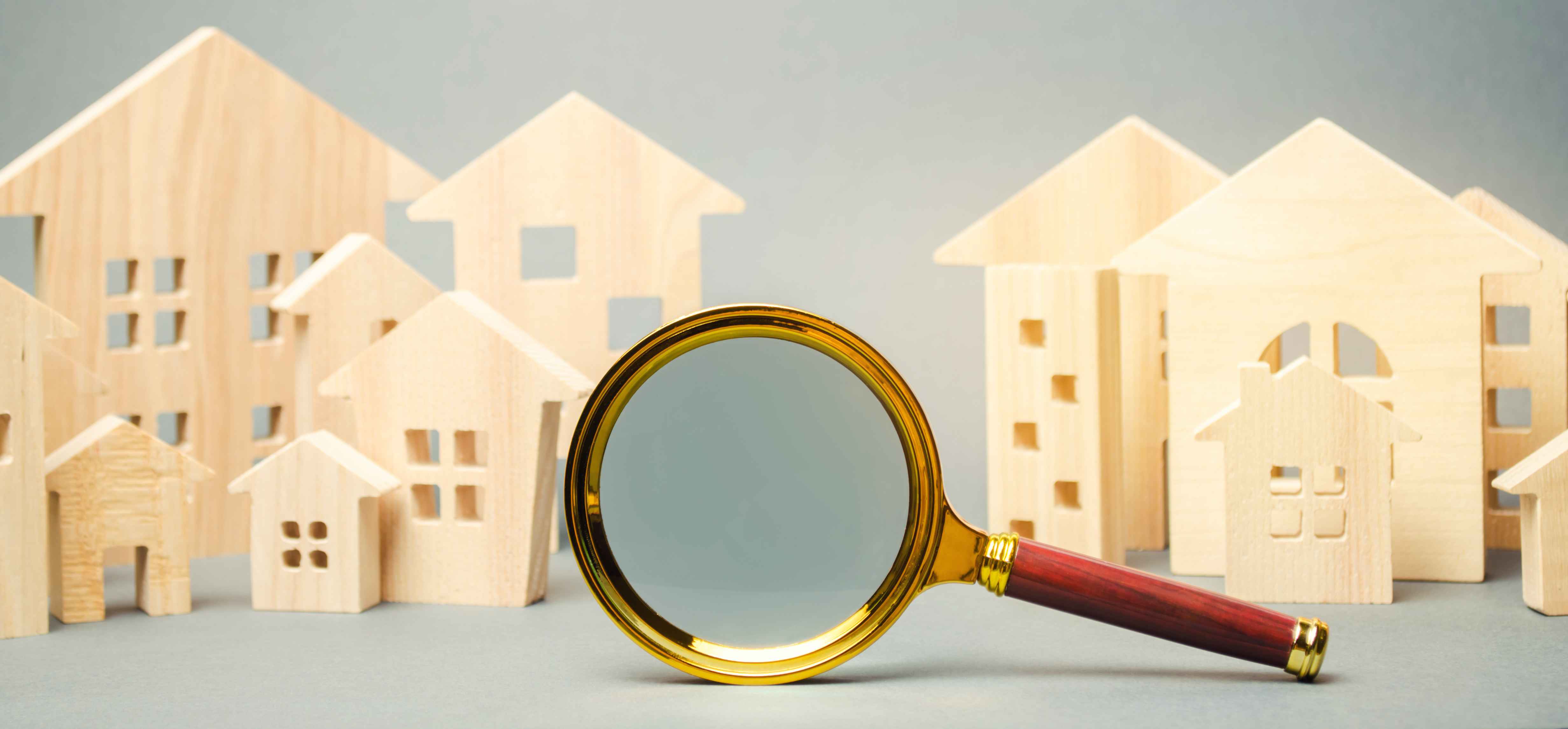 magnifying glass searching how much is my home worth with wooden houses