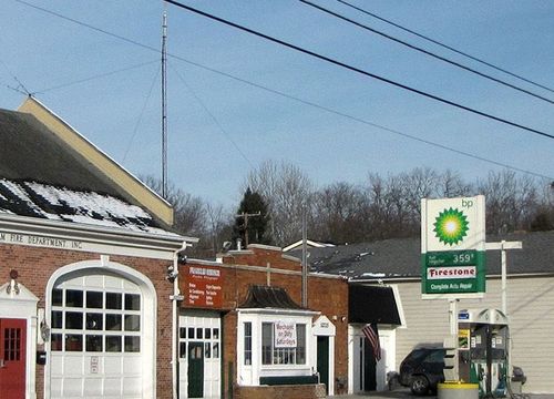 The image shows a gas station with a large sign for BP and Firestone
