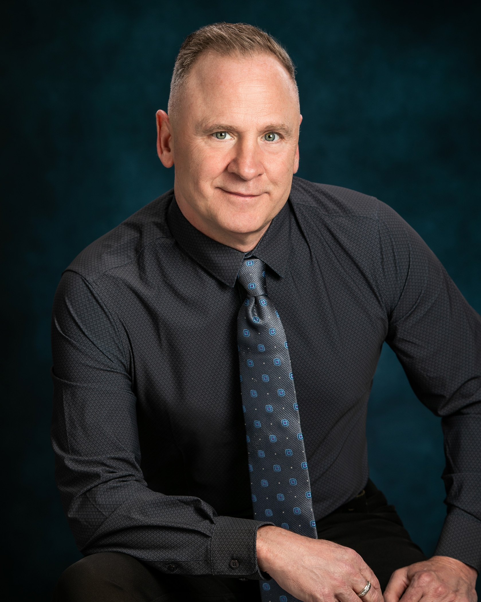 Realtor Tom Gilliam wearing a black shirt and tie