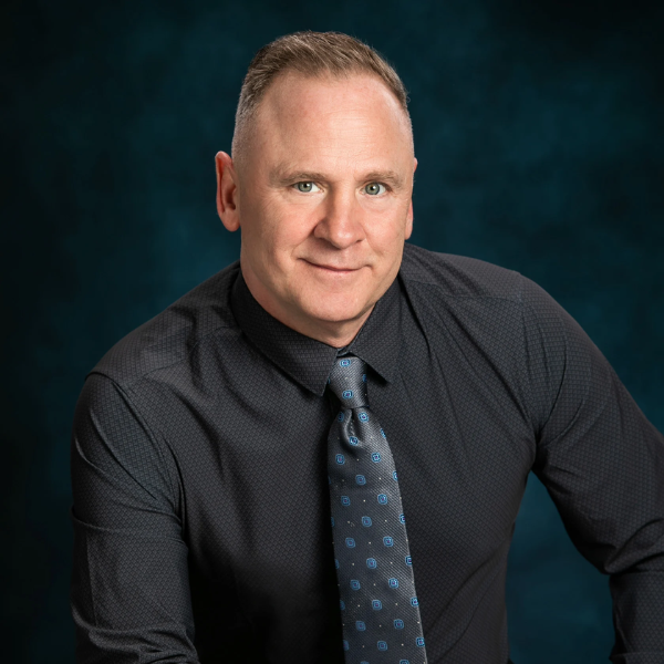 Tom Gilliam in black shirt and tie with formal look