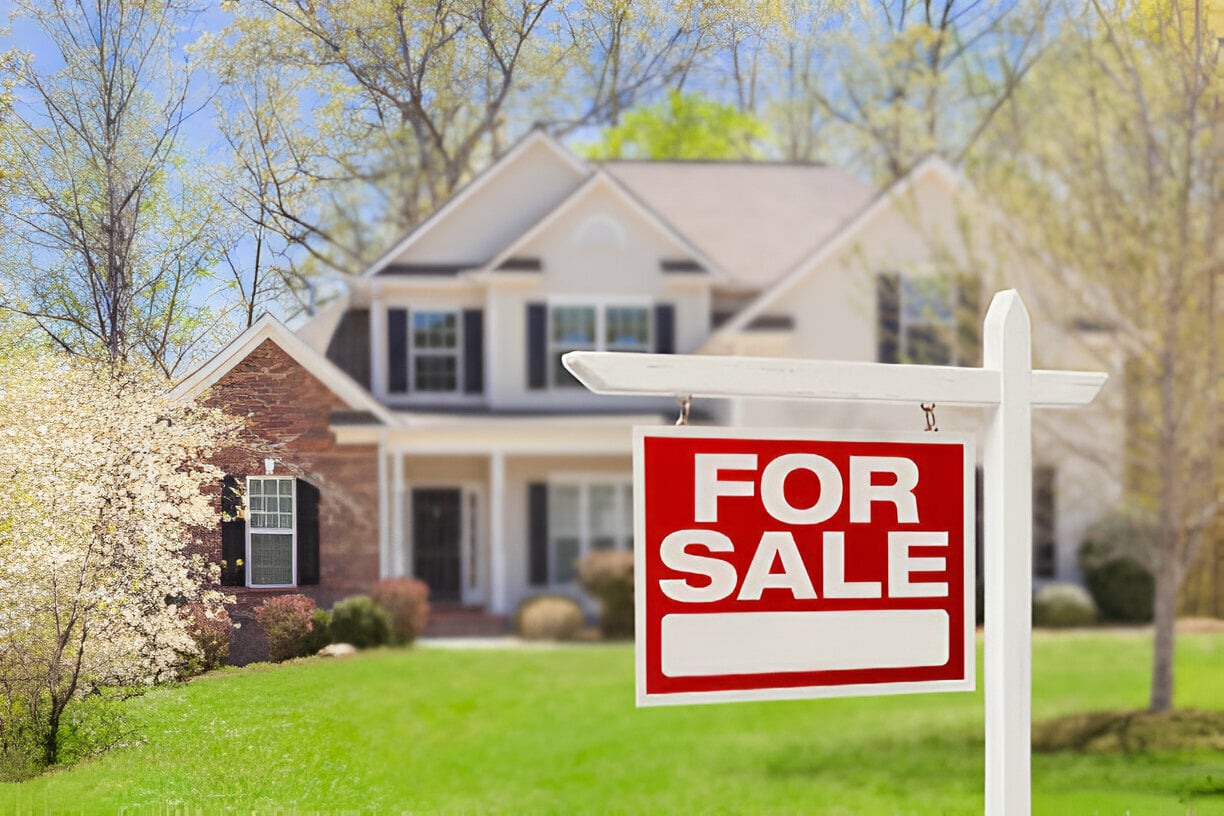 Signboard displaying 'Home for Sale' text in front of house