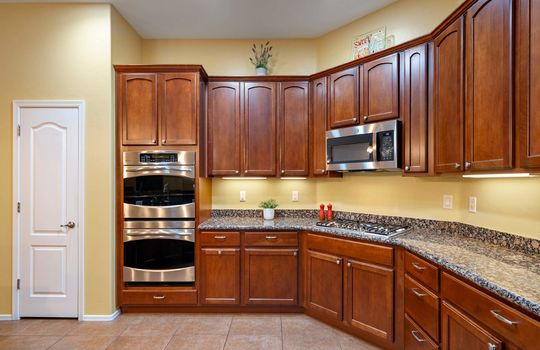 Cherry cabinets are fully stocked with all you need—cookware, glasses, dinnerware, cutlery and more!