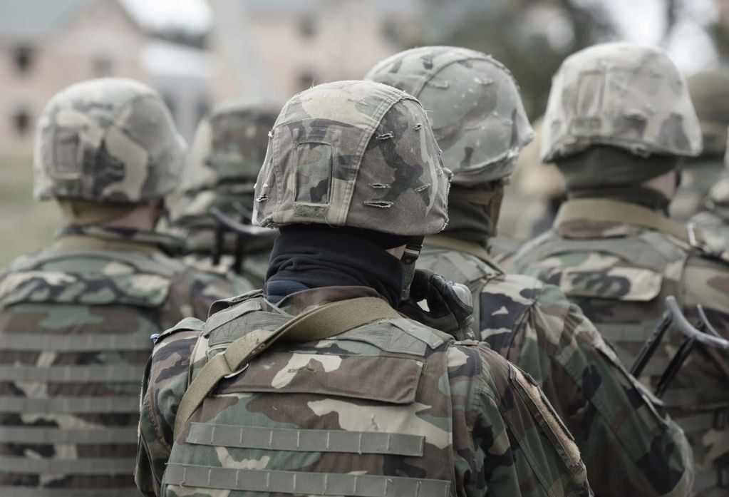 Military members in full uniform photographed facing away.