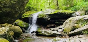Waterfall over mossy rocks at Otter Falls Trail in Seven Devils, NC.
