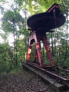 Rusted red ski lift abandoned in historic Mill Ridge neighborhood.