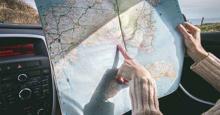 Woman pointing at a road map planning her day trip from Boone, NC.