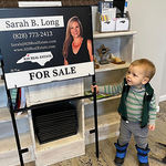Toddler looking at a for sale sign from 828 Real Estate's Sarah Long.
