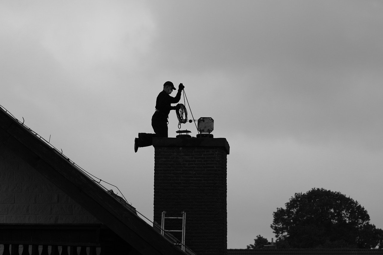 Chimney sweep maintaining the fireplace and chimney of a house in Boone, NC.