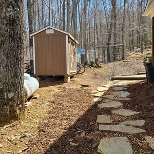 backyard with stone pathway, mulched walkway and storage shed.