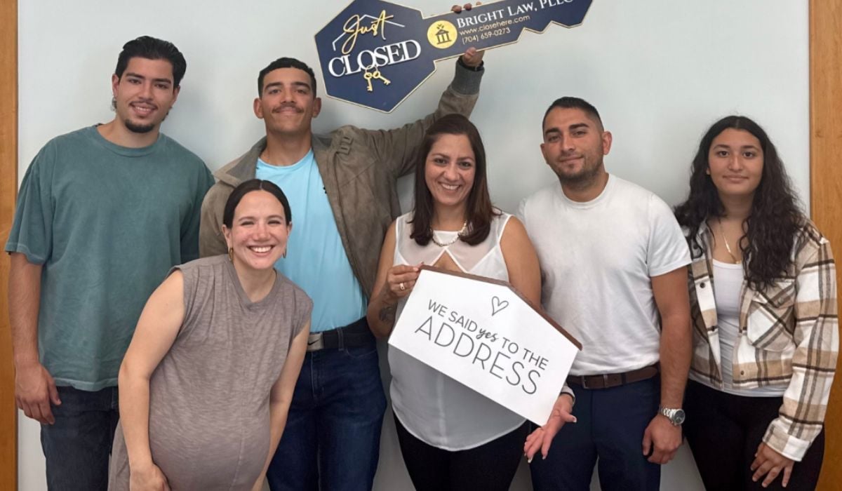 Isamar and Juan celebrating the purchase of their first home in Bessemer City, NC with Stone Realty Group agent Sofia Corona outside their new home.