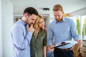 Home inspector explaining his report to real estate buyers