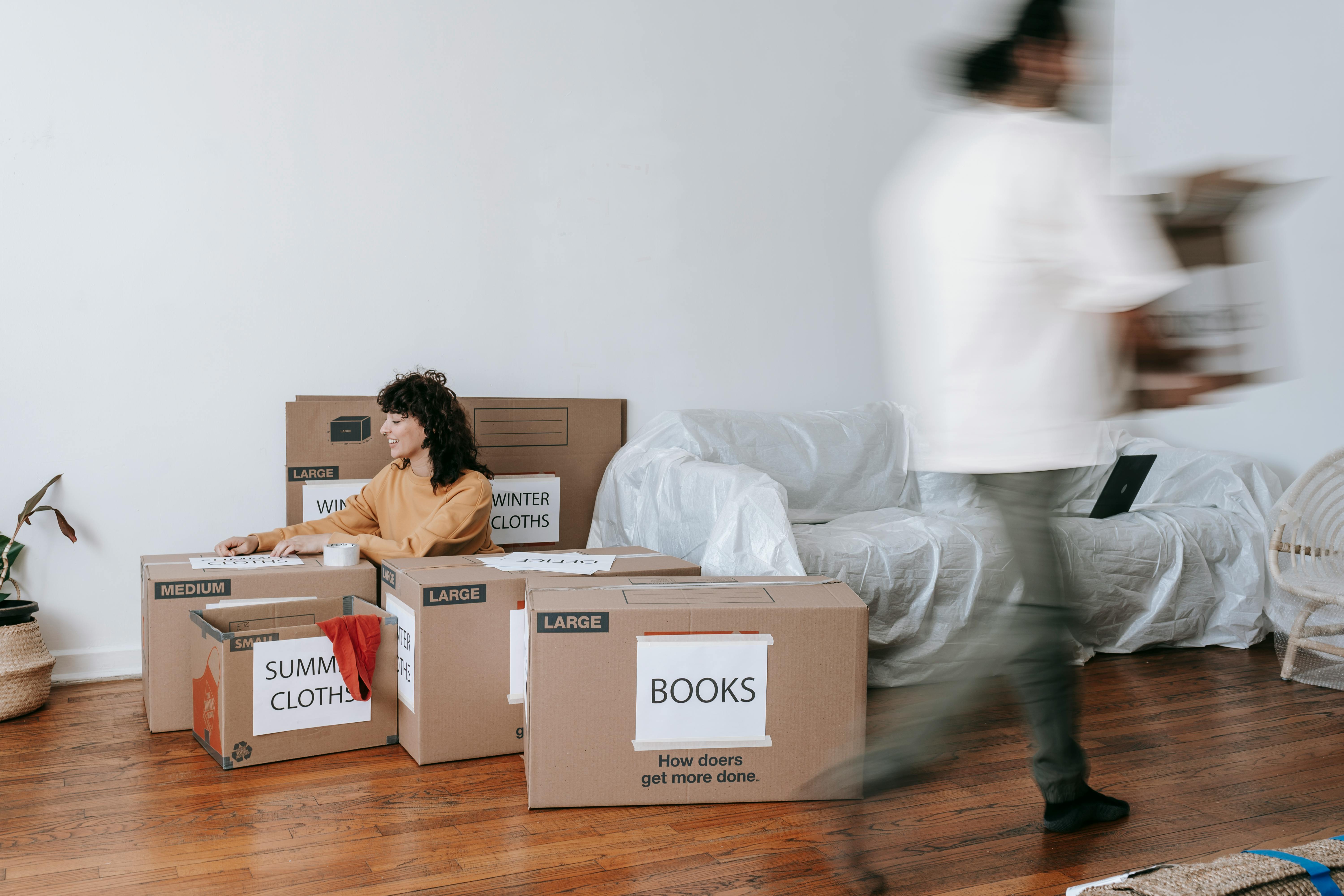 Man and Woman decluttering their living space using the 5-bin approach.