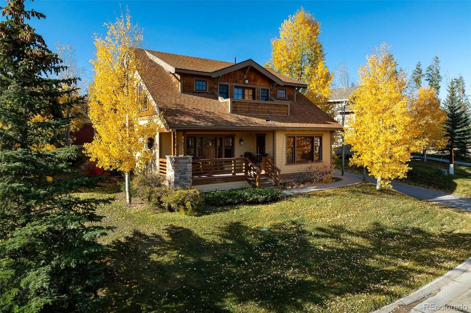 Fall view of a two-story craftsman-style home with front porch and golden aspens in Grand Park, Fraser, Colorado