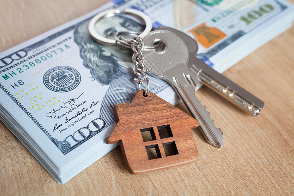 Real estate investing concept. American dollar, cash or housing. Keys close-up