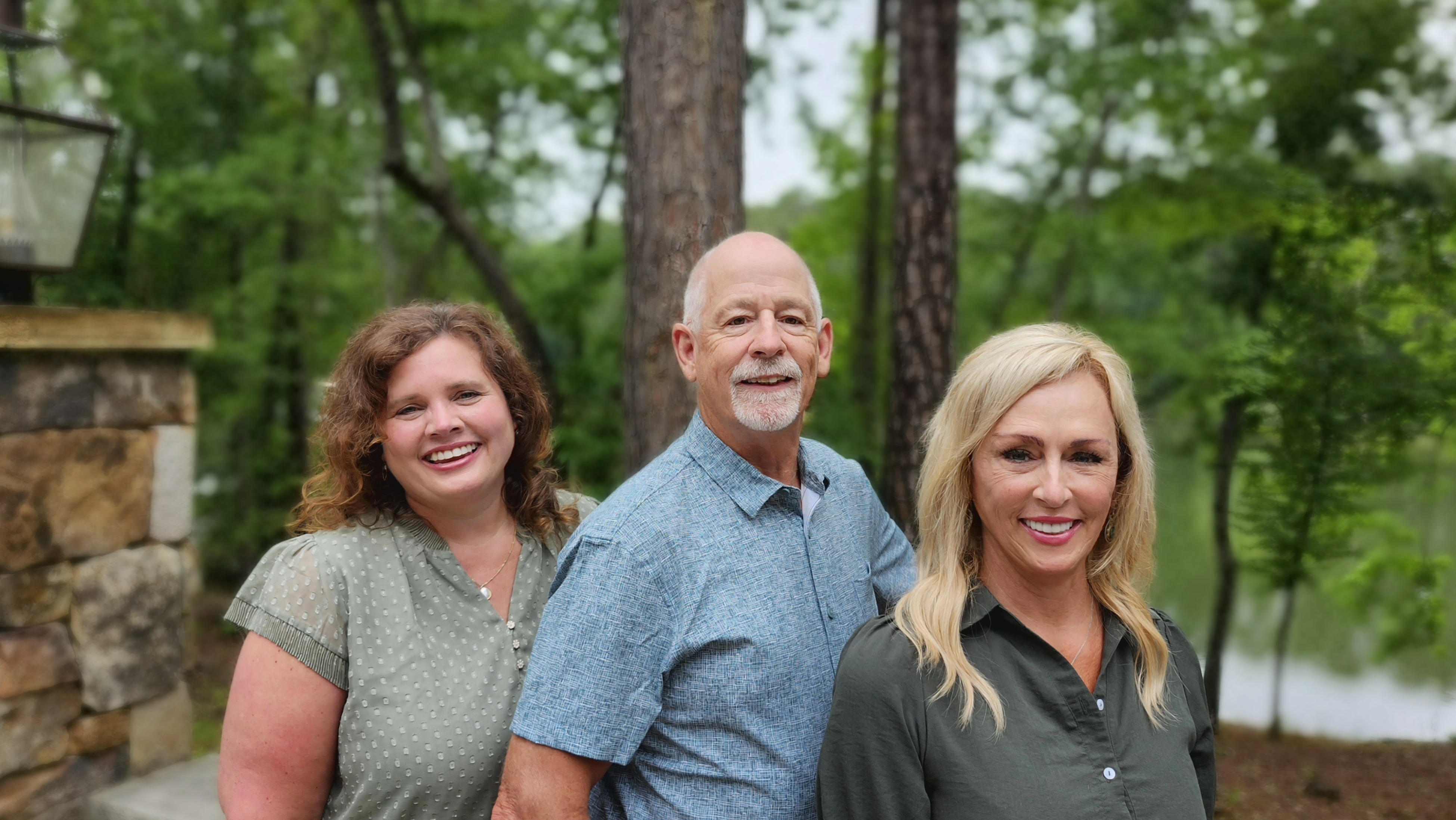 Greene Advantage Real Estate agents smiling together by the water at Savannah Lakes Village