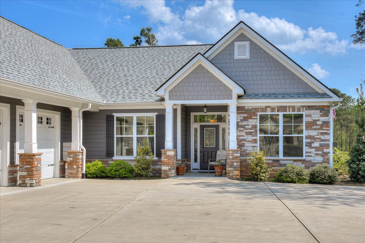 Single-level ranch home with front porch and low-maintenance landscaping.