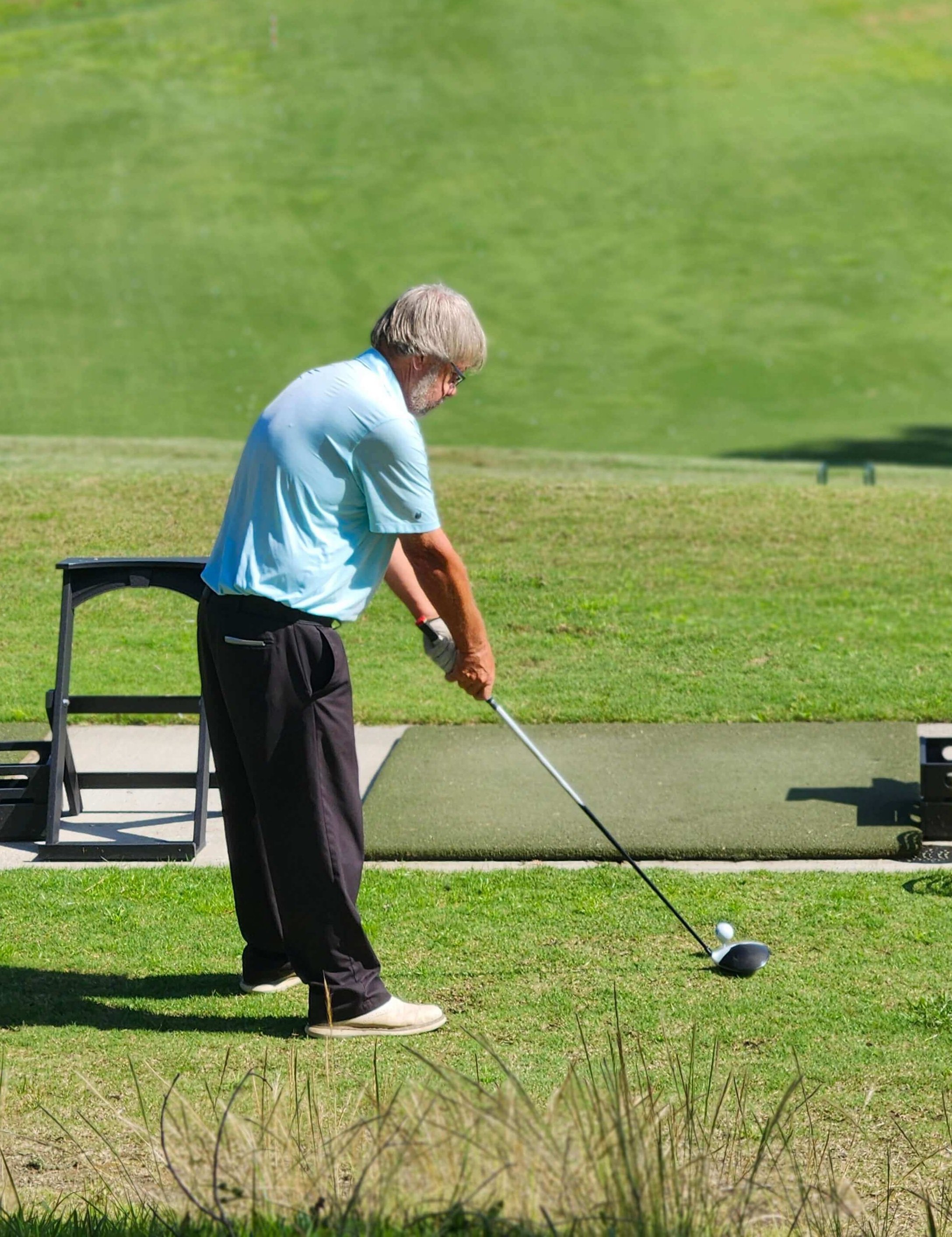 Golfer warming up on Monticello driving range for the day's challenges.
