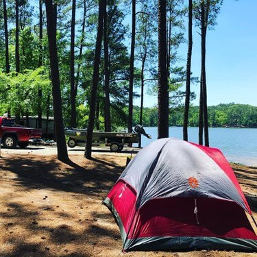 Lakeside campsite shaded by pines at Baker Creek State Park
