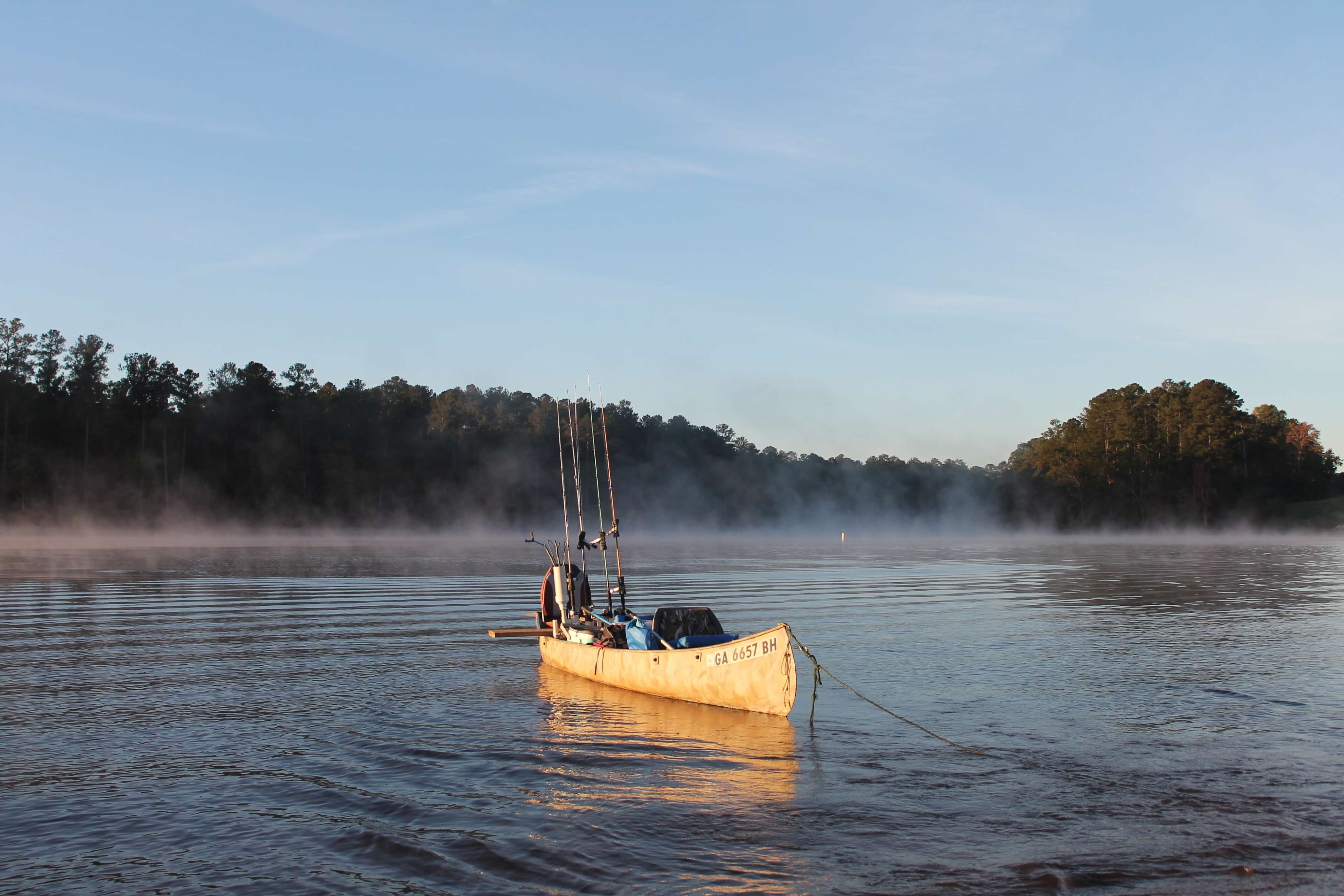 Angler in a sit-on-top fishing kayak with rod holders and tackle crate on Lake Thurmond