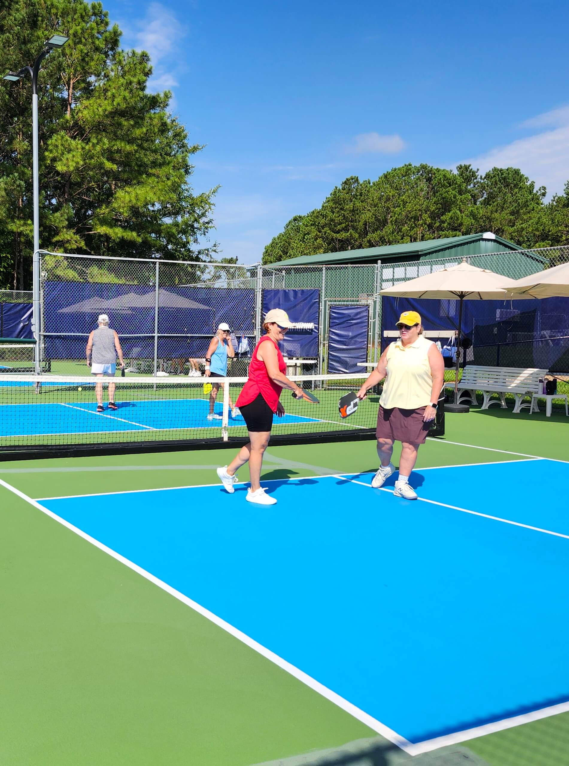 Active adults playing pickleball at Savannah Lakes Village recreation center