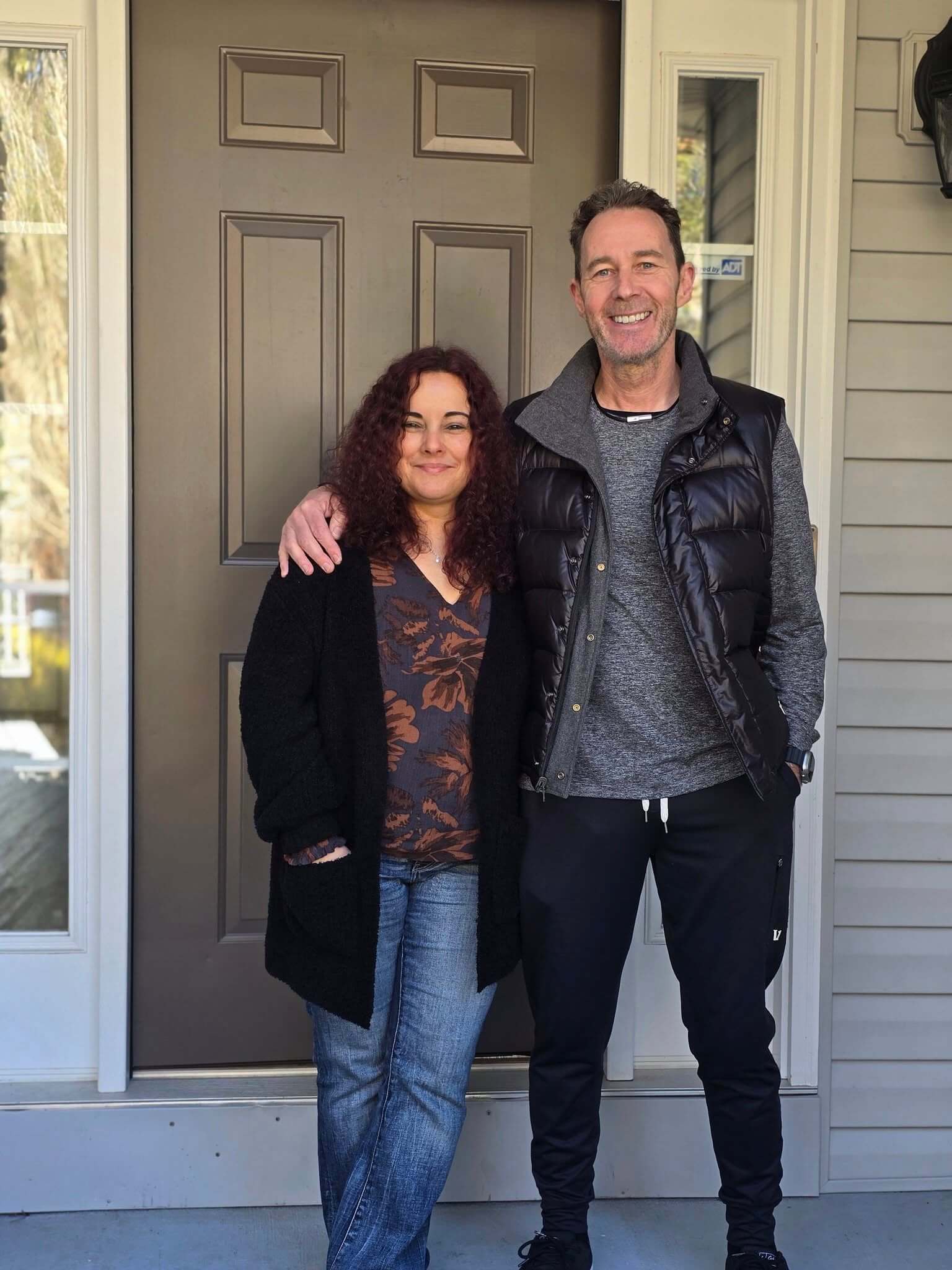 New homeowners receiving keys in front of a Savannah Lakes Village home during a winter closing