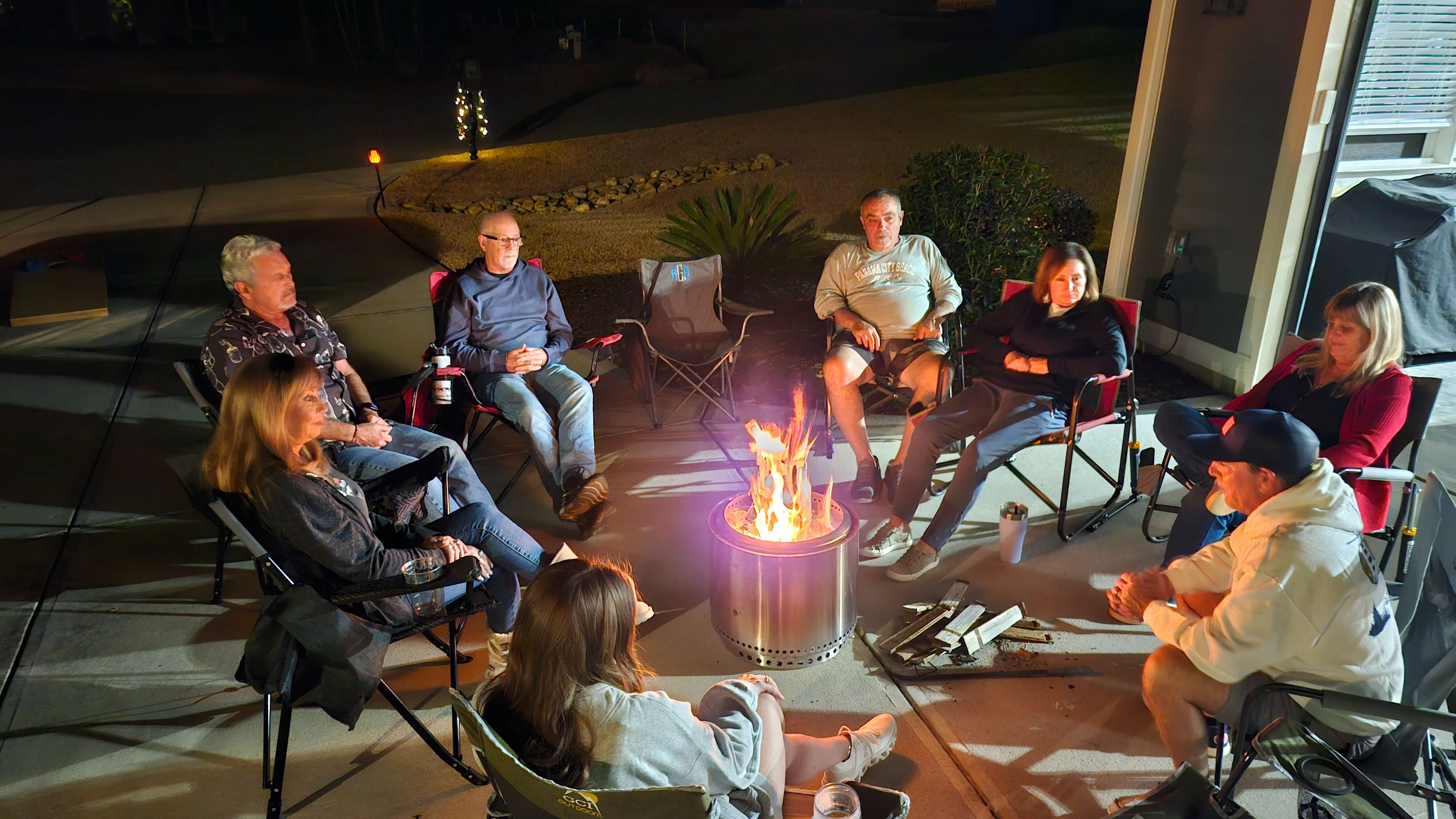 Neighbors meeting around a fire pit on a clear winter evening