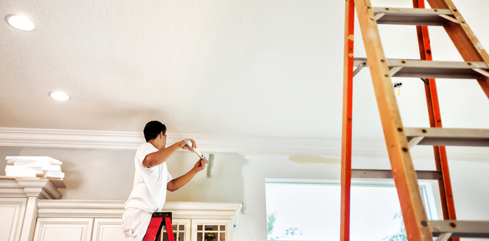 House painter painting wall with a paint roller
