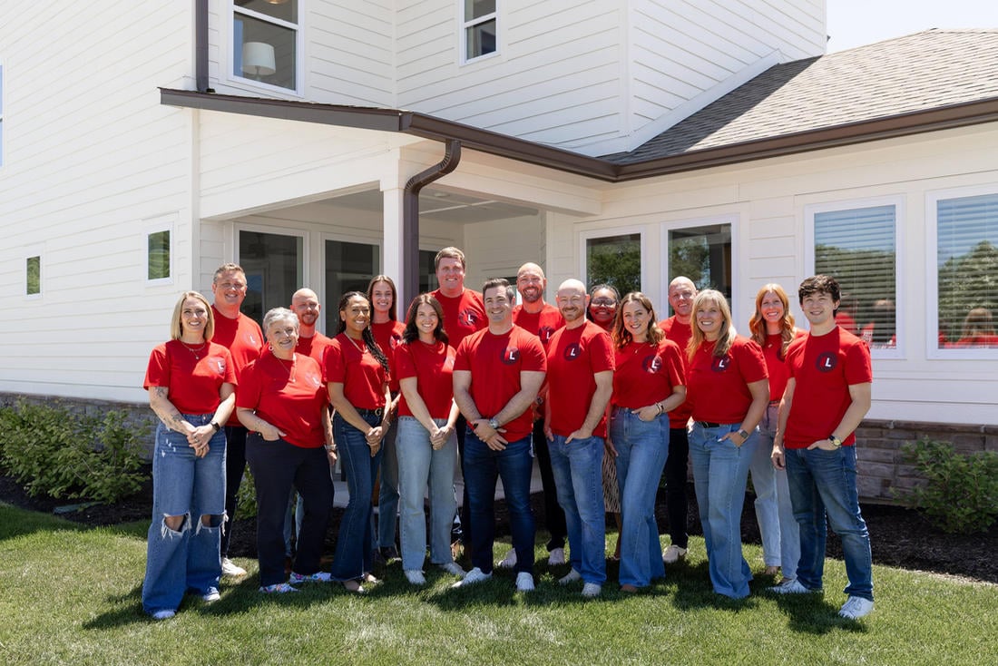 Team of Indianapolis real estate agents at Lockstep Realty standing outside a home