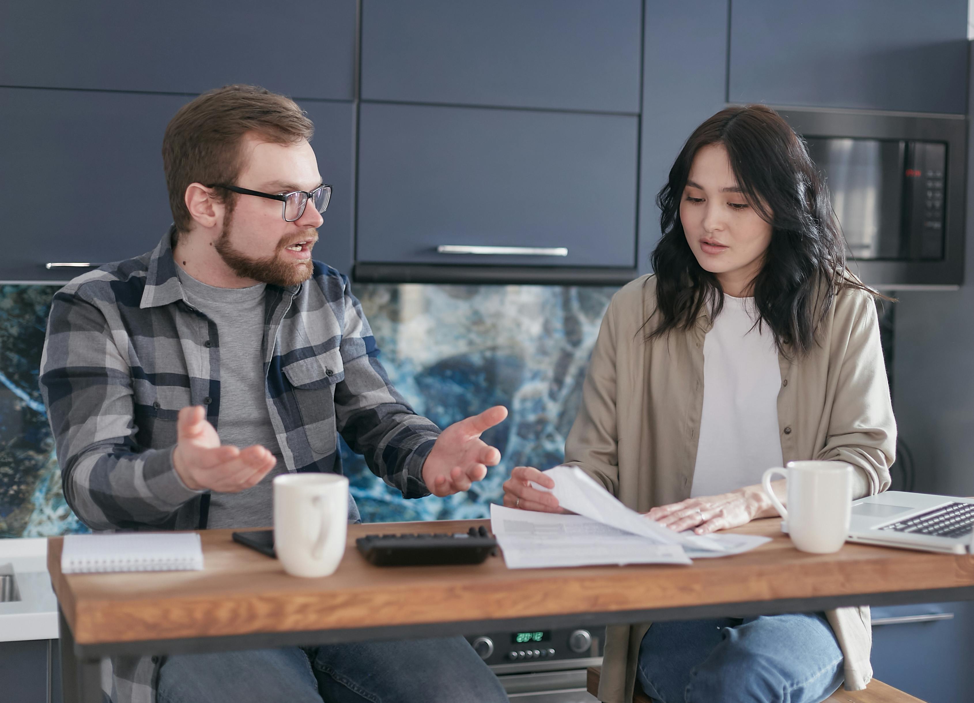 family reviewing mortgage documents and calculator at kitchen table to decide between fixed and adjustable rate loans