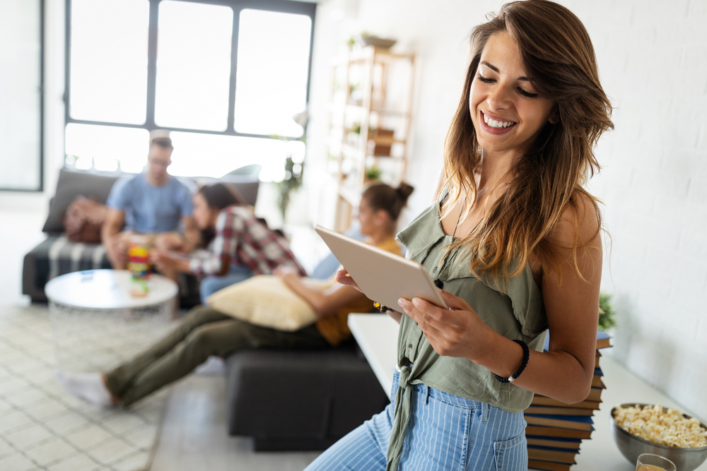 Happy young woman using tablet pc in loft apartment