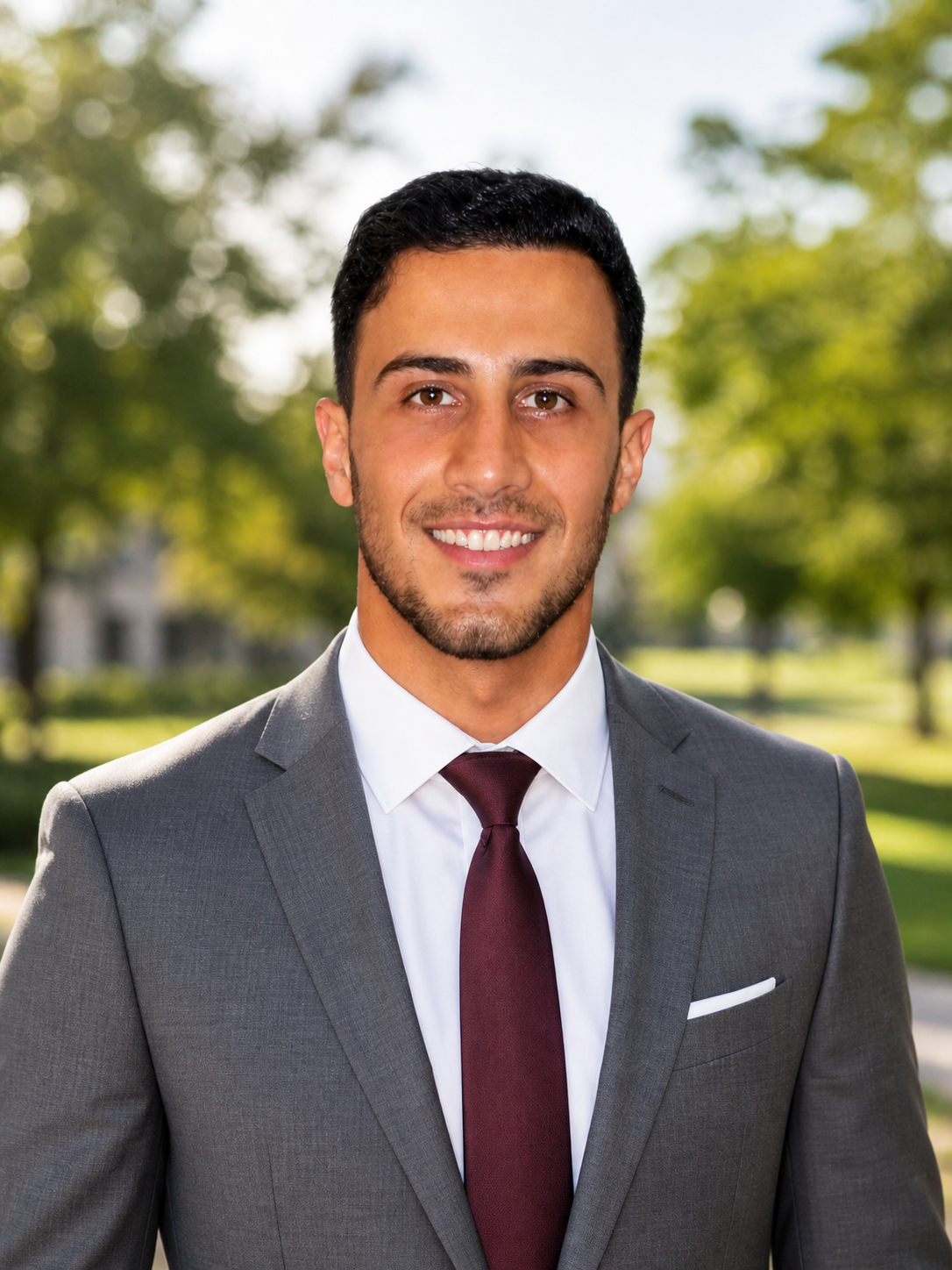 Ismael Omari headshot in a park with a slightly blurred background