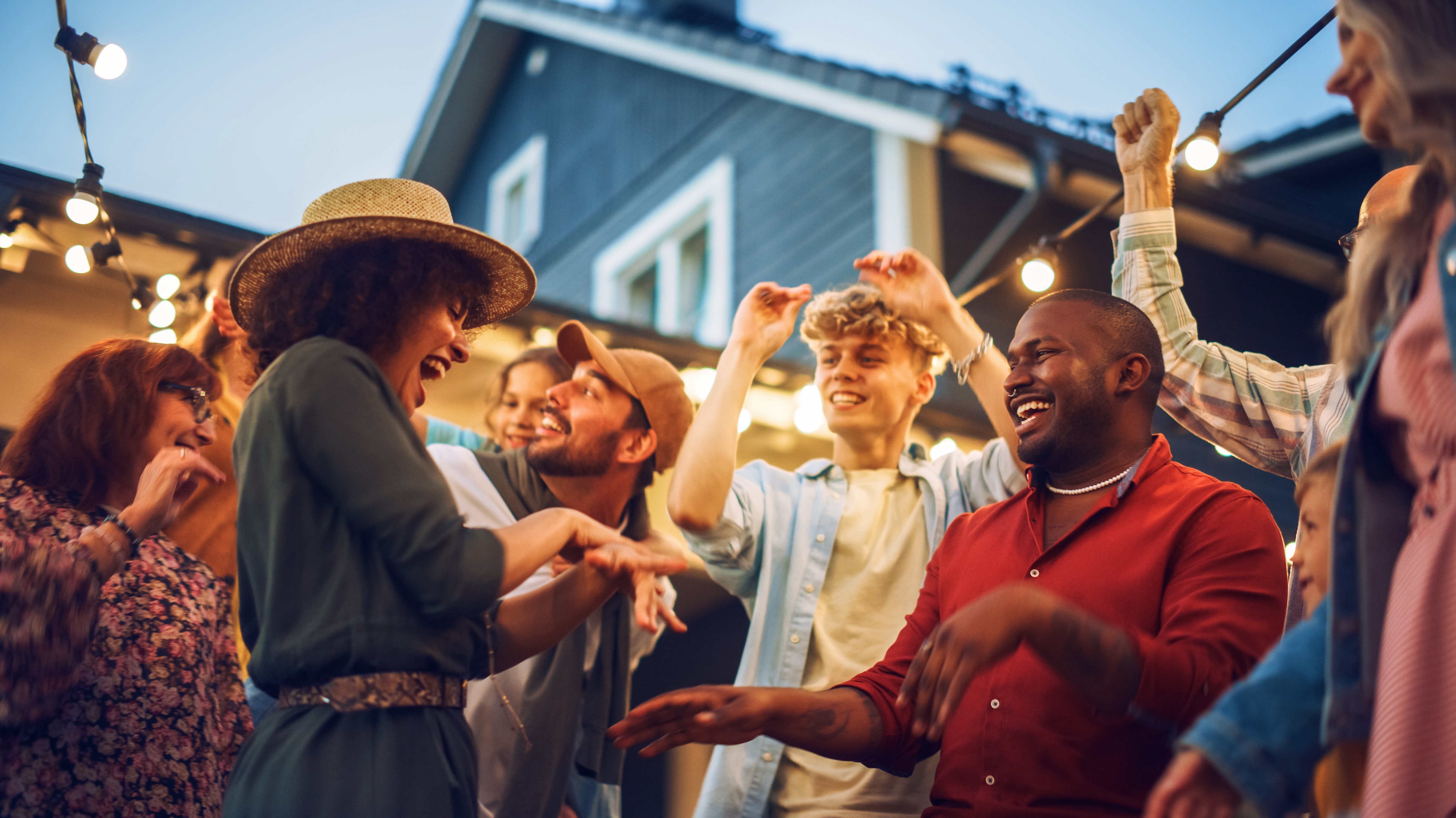 Diverse Multicultural Friends and Family Dancing Together at an Outdoors Garden Party Celebration. Young and Senior People Having Fun on a Perfect Summer Afternoon.