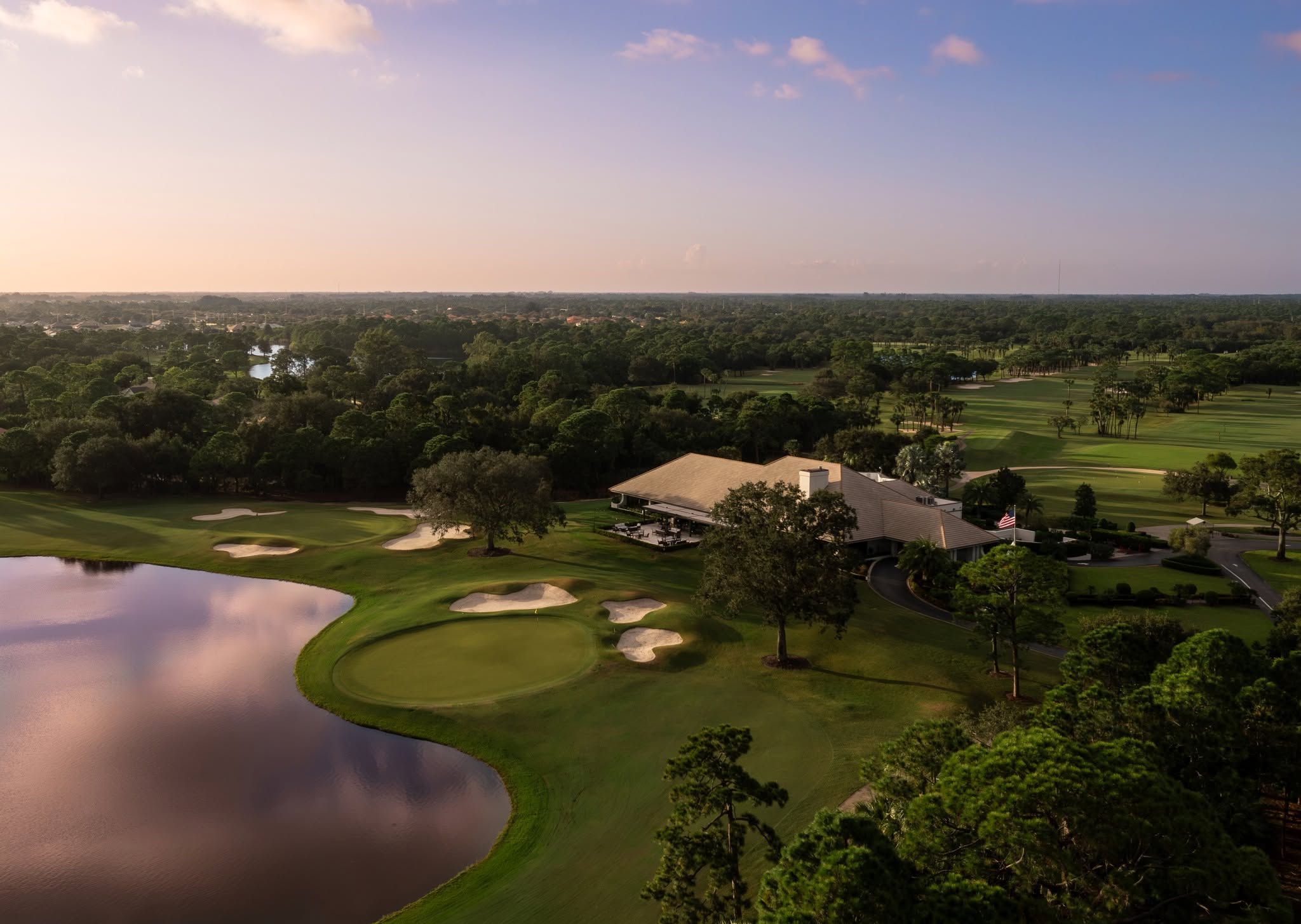 Aerial view of a Bent Pine fairway beside a lake and mature trees