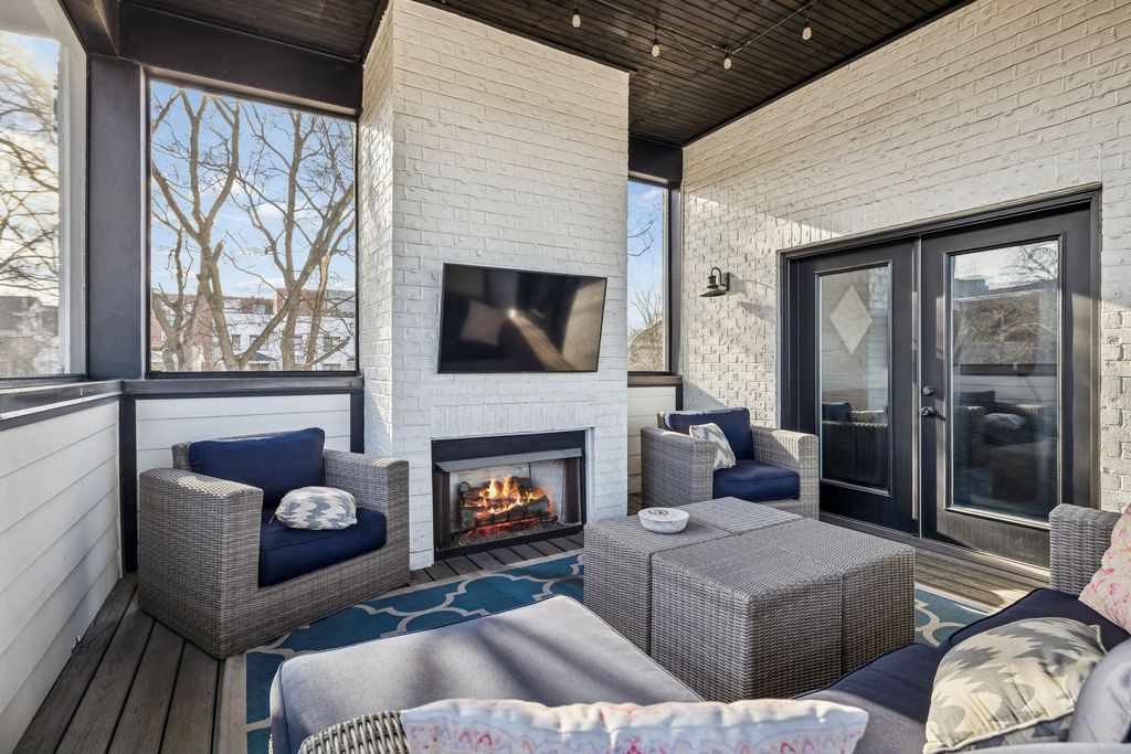 Screened outdoor porch with fireplace and seating at 607 Garfield Street, Nashville TN 37208