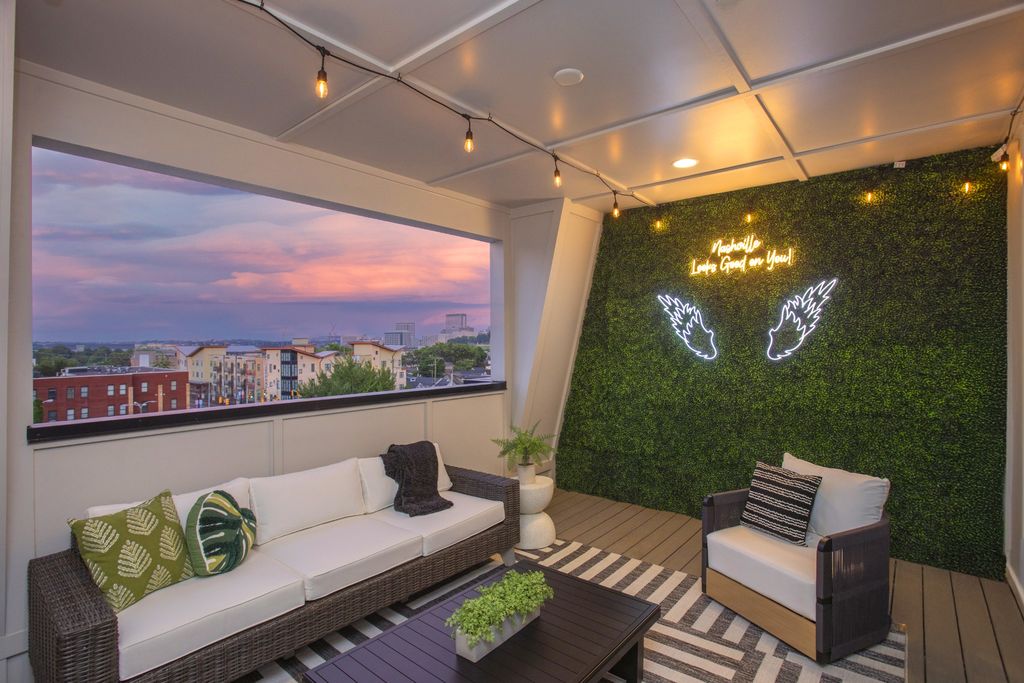 Rooftop terrace at Alora Nashville short-term rental property at sunset with Nashville skyline views and neon sign reading Nashville Looks Good on You