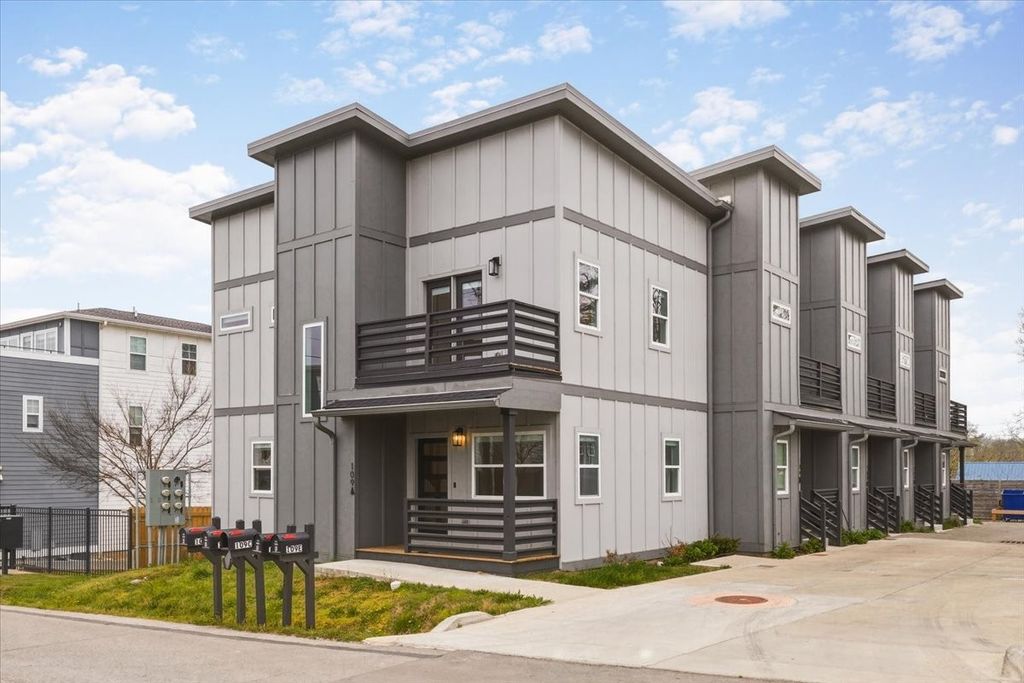 Exterior of 109 A Duke St Nashville TN, a 2023 modern gray board and batten townhome complex in East Nashville featuring second-floor balconies, black horizontal railings, and covered entry, listed by BDG Partners at Compass