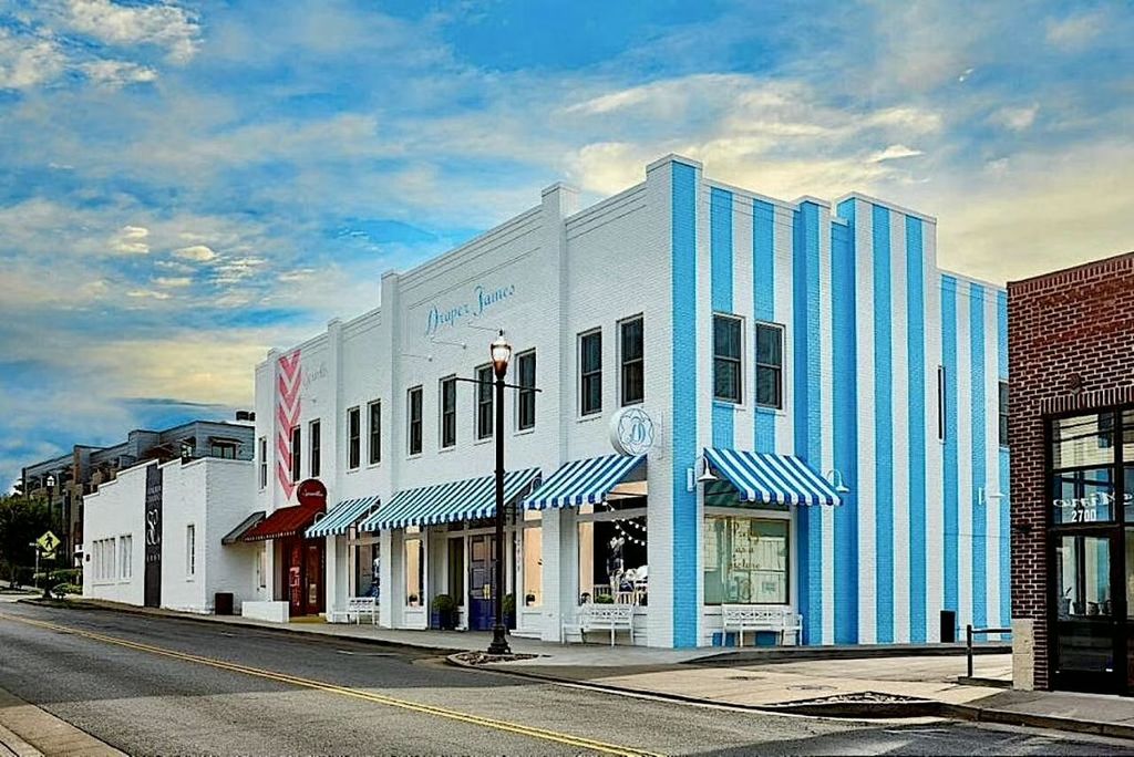 Commercial storefronts along 12 South Nashville TN including Draper James boutique with blue and white striped awnings