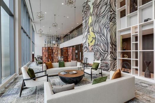 Luxury lobby social lounge amenity at 505 Nashville highrise condominium at 515 Church Street featuring double height ceilings, large scale wall mural, and designer seating in downtown Nashville