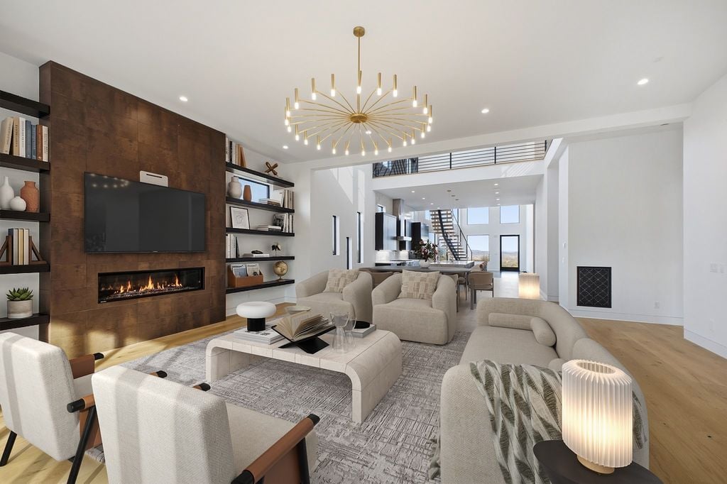Open concept living room at 5425 Franklin Pike Nashville TN, an Oak Hill luxury new construction home featuring a linear gas fireplace with wood accent wall, gold sputnik chandelier, wide plank hardwood floors, built-in shelving, and open sightlines to the kitchen and floating staircase, listed by BDG Partners at Compass
