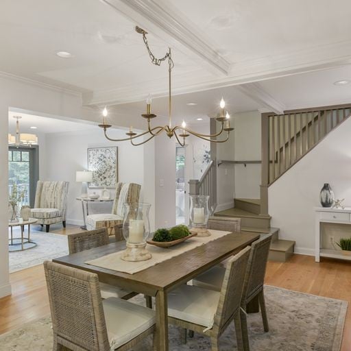 Dining room and staircase inside a Green Hills Nashville home in 37215 with open living area and brass chandelier