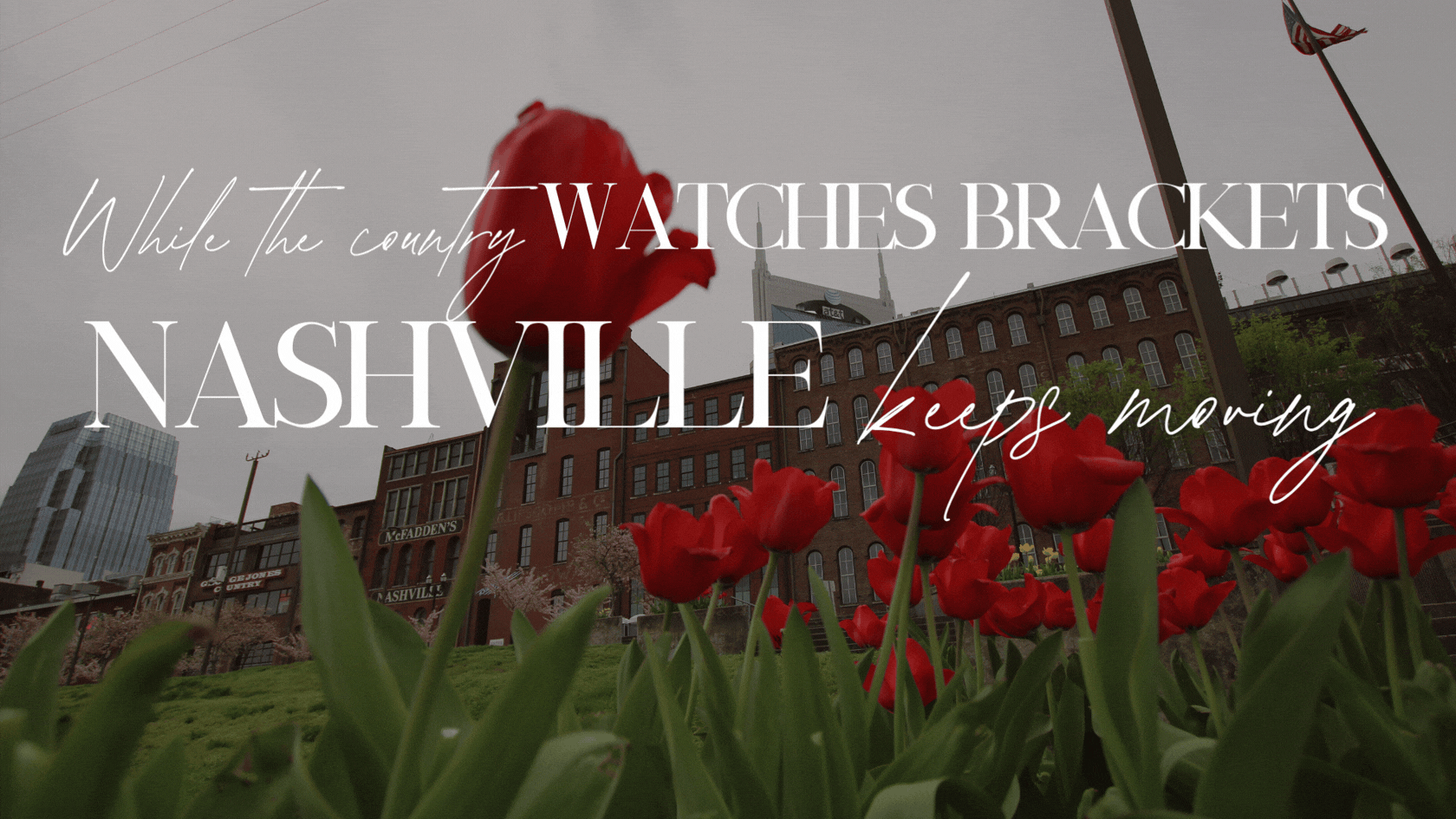 Red tulips in foreground, Nashville downtown skyline with AT&T building and brick buildings, early spring