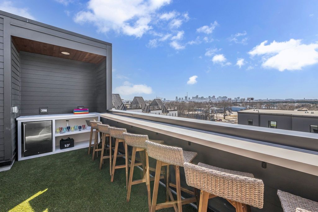 Rooftop deck with bar seating, turf, and downtown Nashville skyline views at 1307 Baptist World Center Drive Unit G, a fully furnished non-owner-occupied short-term rental listed at $1,150,000