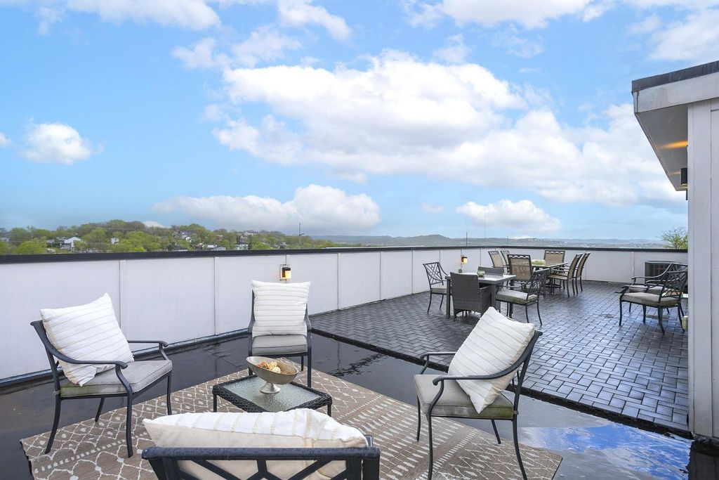 Rooftop deck with outdoor seating and panoramic views of Nashville's rolling green hills at 400 36th Avenue North, a turnkey short-term rental in West Nashville Tennessee listed at $899,000