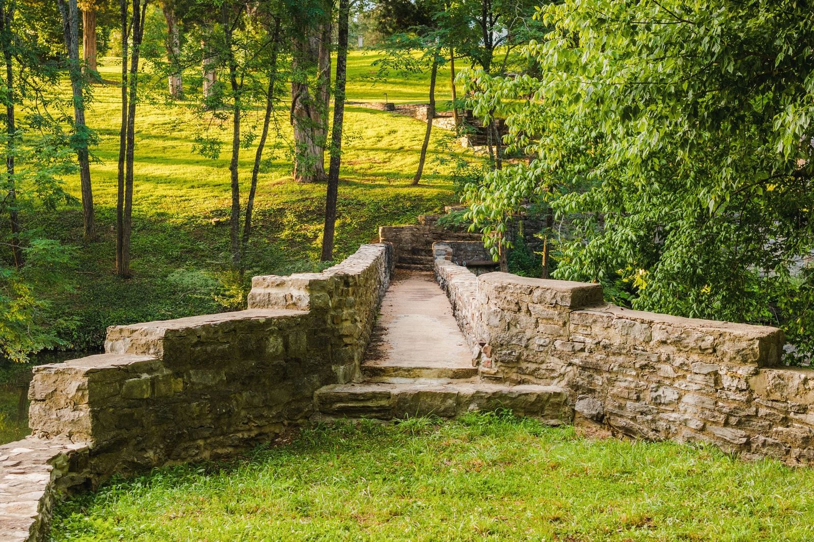 The restored stone pedestrian bridge over Richland Creek at 4753 Post Road, with parkland beyond, Hillwood Nashville