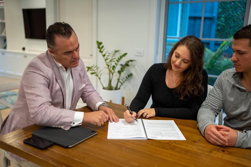 Real estate agent reviewing home inspection negotiation documents with buyers