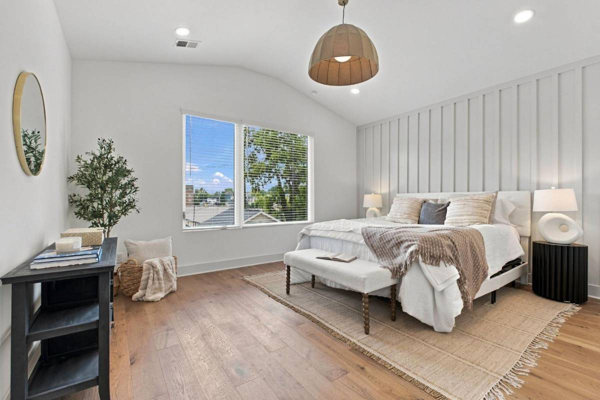 Main-level primary bedroom at 2915A Davis Avenue with a vaulted ceiling and paneled accent wall