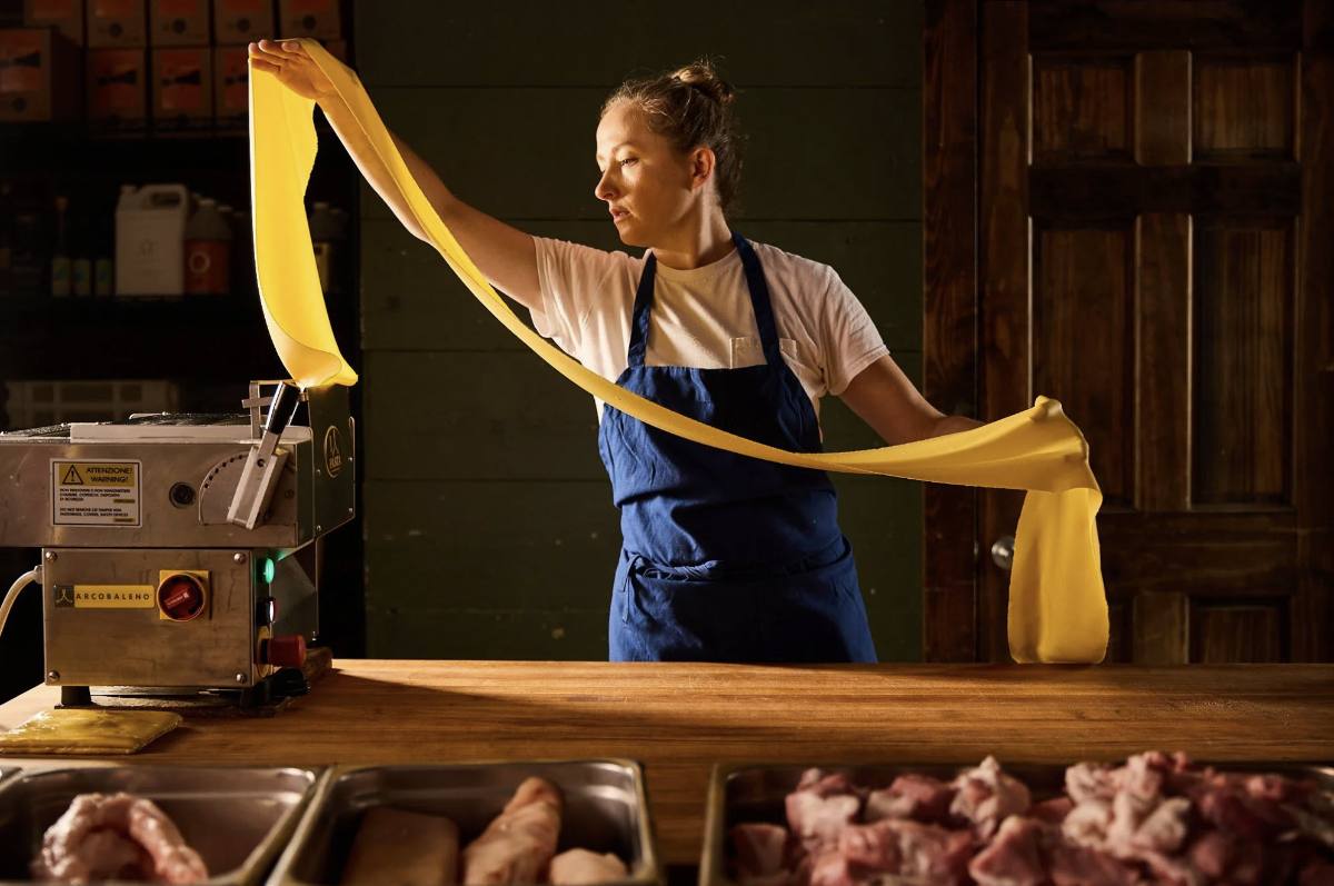 A cook stretching fresh pasta in a Germantown Nashville restaurant kitchen, part of the neighborhood dining scene near 1200 5th Avenue North