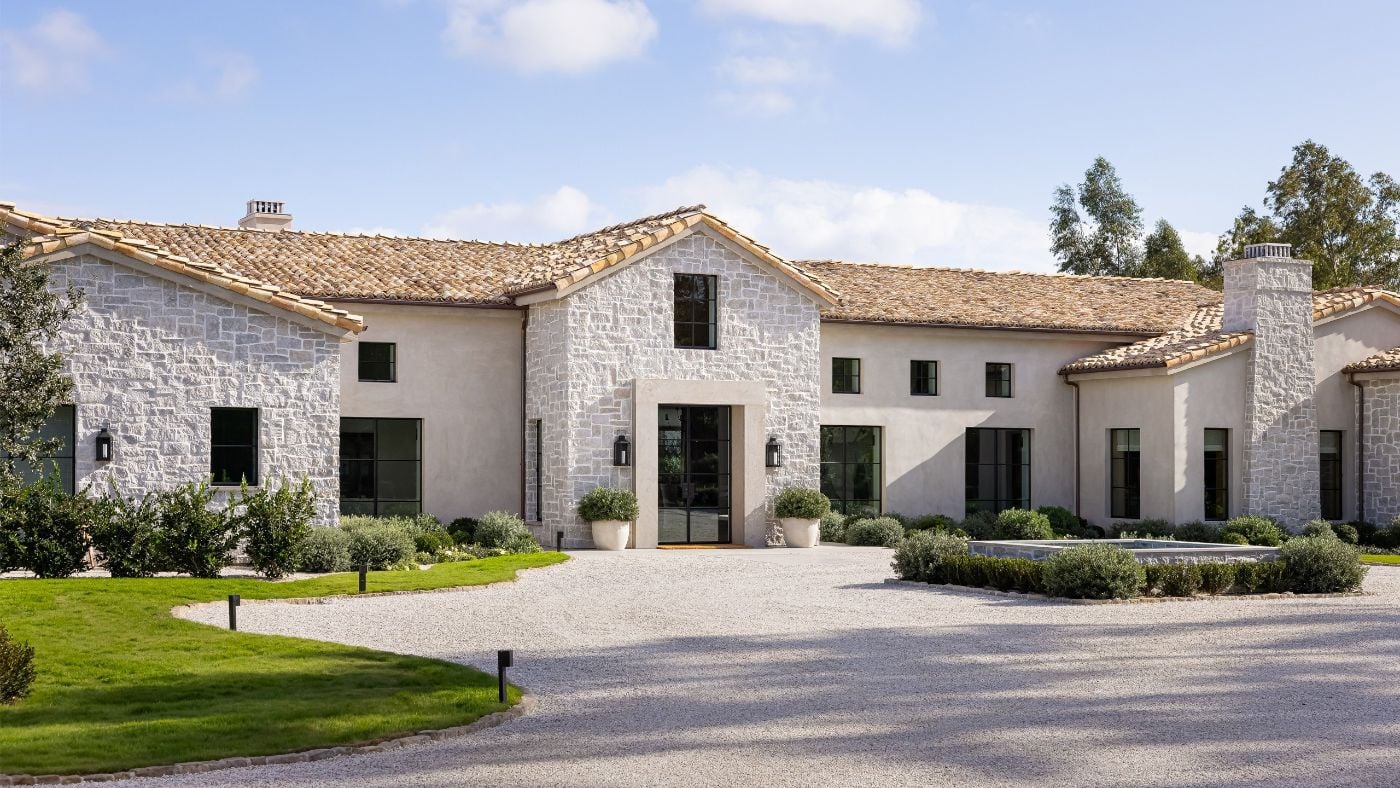Stone one-level luxury home with clay tile roof and circular drive, an example of one-level living luxury buyers are prioritizing in Davidson and Williamson County