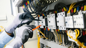 Electrician using probes to test circuit breakers in a residential panel in St. Augustine Florida.